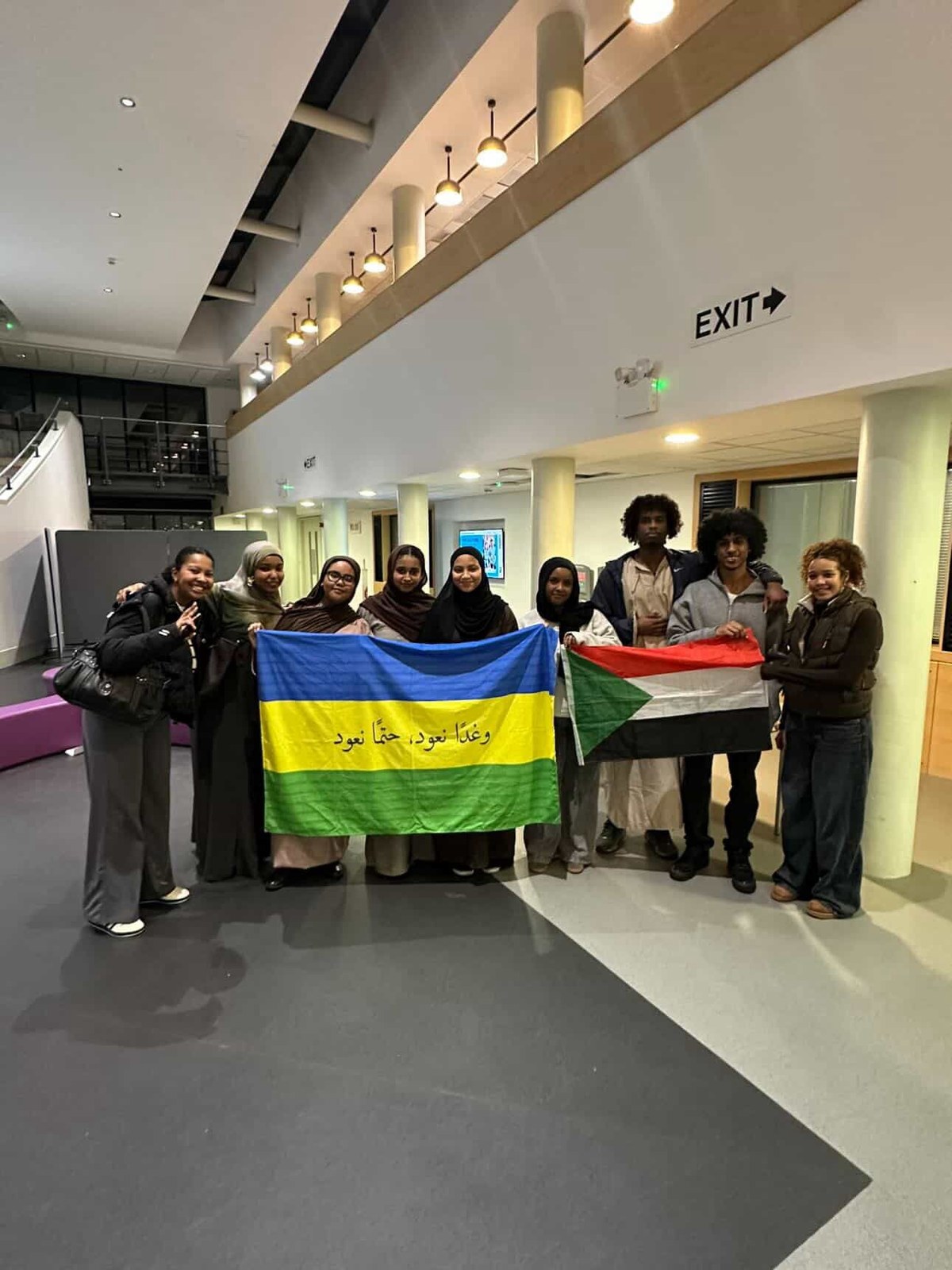 Warwick Sudani Society community members holding flags
